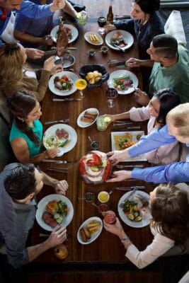 servers bringing food to large table at Fogo de Chao