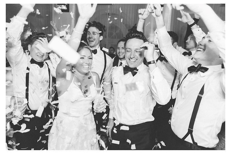 bride and groom dancing as confetti falls around them