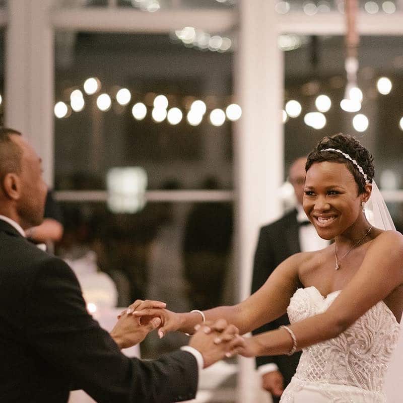 bride smiling as she dances with her new husband at their wedding reception