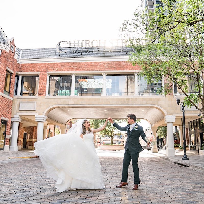 bride and groom holding hands on the brick street of Church Street in downtown Orlando