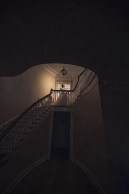 bride standing in front of window next to stairway landing