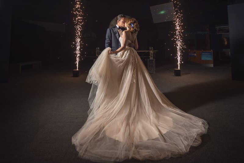 bride and groom kissing while sparks fly behind them