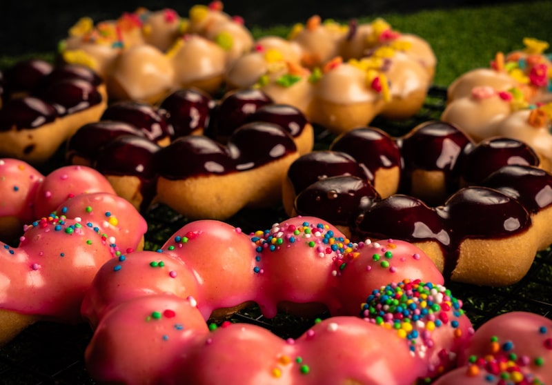 gourmet donuts with various toppings like chocolate icing and rainbow sprinkles