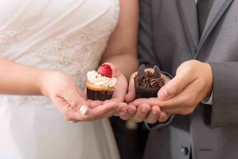 bride and groom holding mini cupcakes from Sweet by Holly in their hands