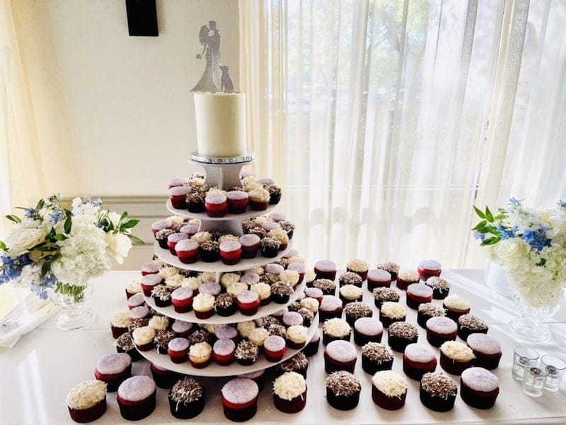 large cupcake display at wedding with multiple different flavors