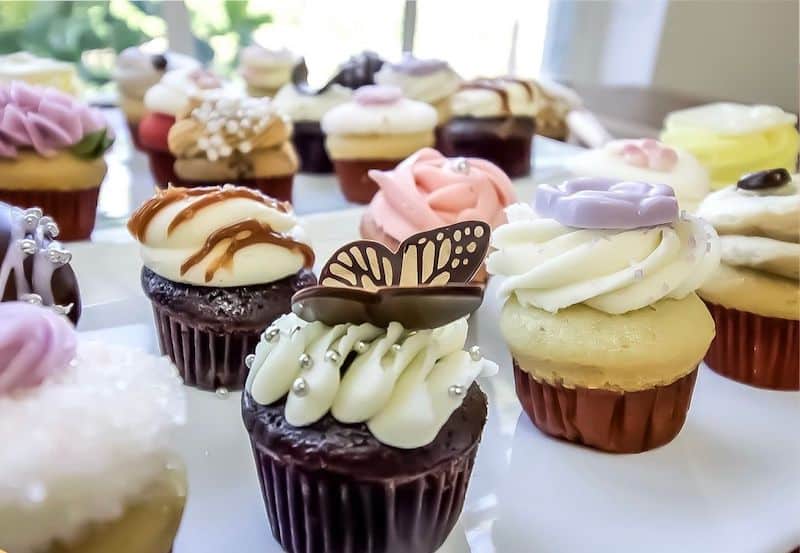 multiple flavors of cupcakes on display at wedding reception