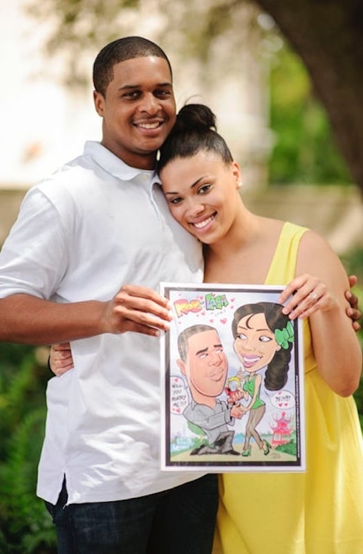 man and woman holding a caricature drawing of the moment he proposed