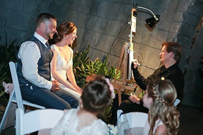 bride and groom modeling for Artistic Talent Group to have a drawing done of them on their wedding day
