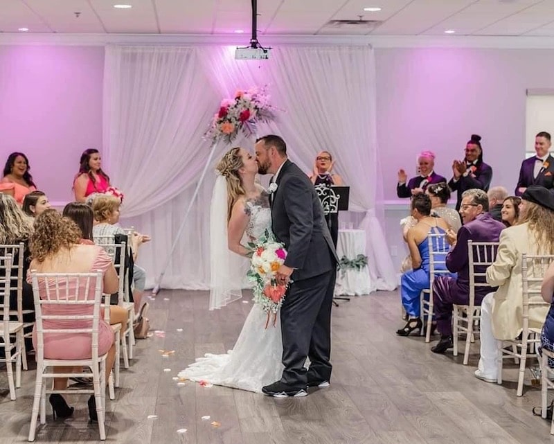 bride and groom kissing during their wedding ceremony at a wedding coordinated by Hearts and Souls Event Management
