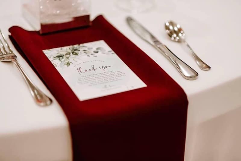 dark red linen with thank you message placed on top at a wedding coordinated by Hearts and Souls Event Management