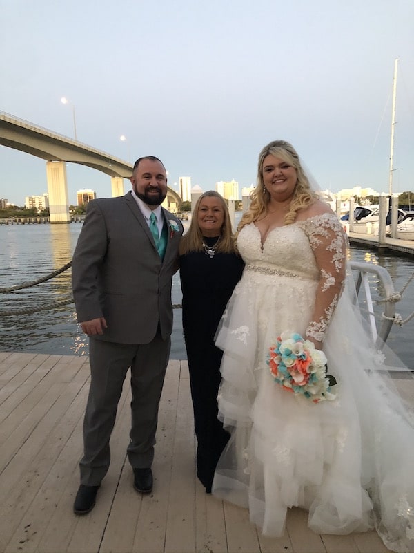 bride and groom standing on dock next to Hearts and Souls Event Management wedding planner