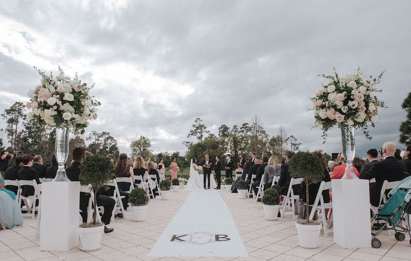 wedding ceremony with a carpeted aisle customized with the bride and grooms initials