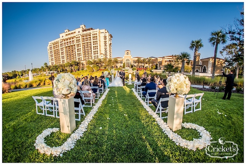 outdoor wedding ceremony with the aisle bordered with white flower petals