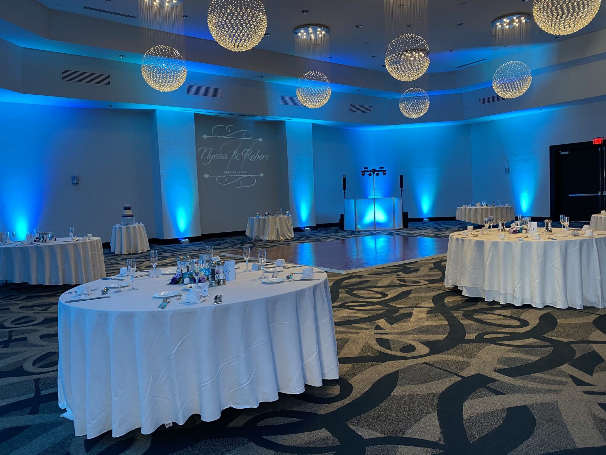 B Resort wedding reception in ballroom with blue uplighting and circle chandeliers