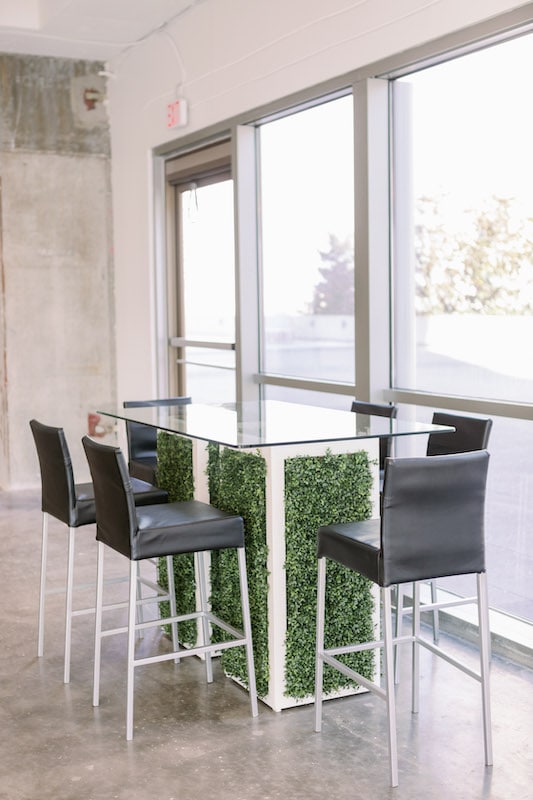 glass table with 6 black chairs provided by CHIC Event Furniture Rental