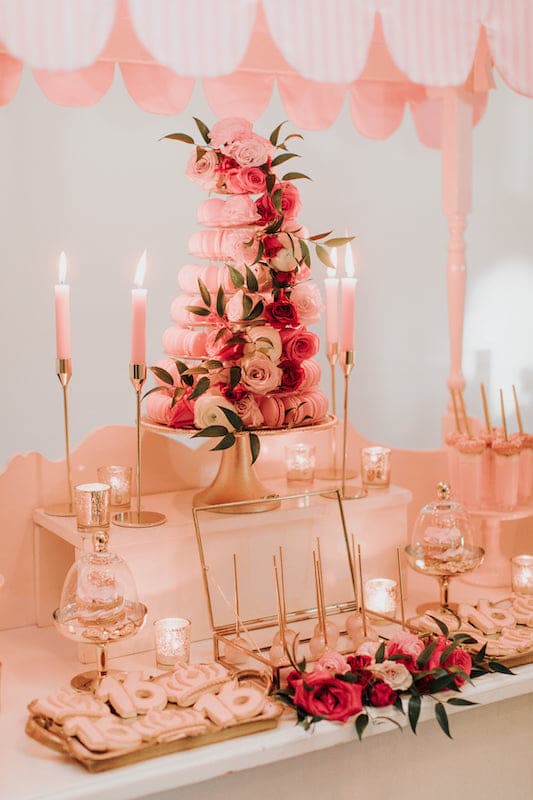 pink themed dessert table featuring cookies, cake pops, and macaroons