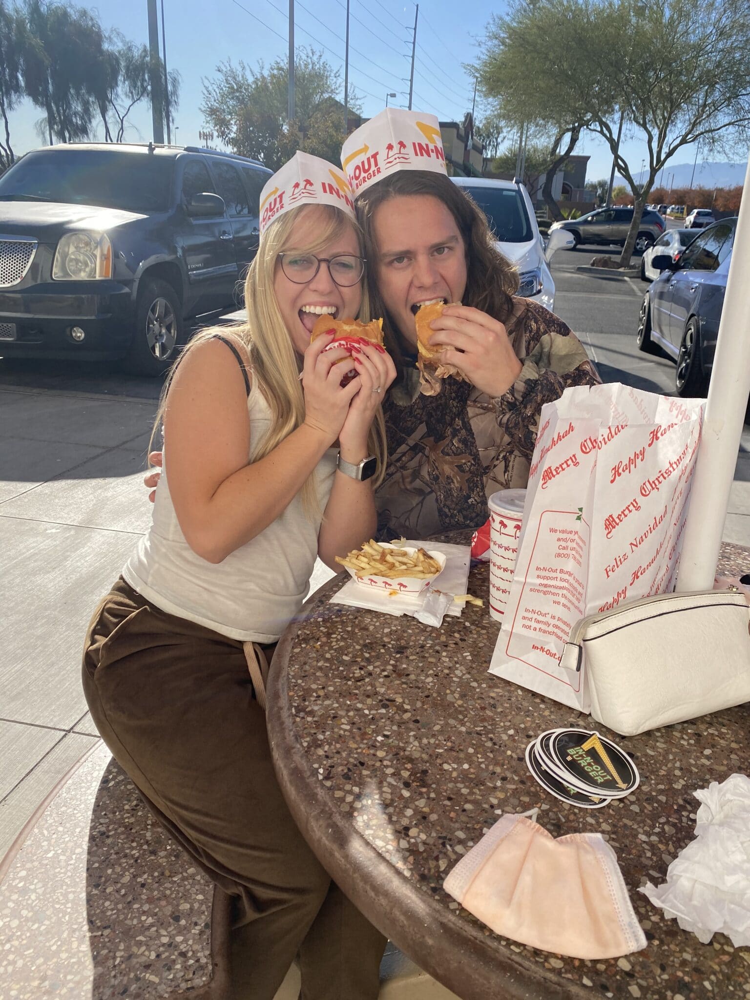 happy couple eating at in n out with hats on