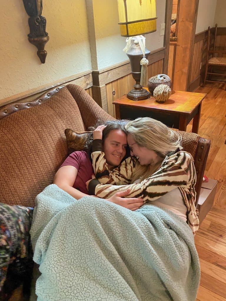 couple cuddling on the couch under a blanket