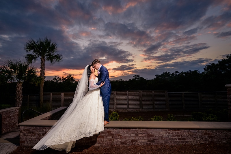 bride and groom embracing outside at sunset by Lazzat Photography