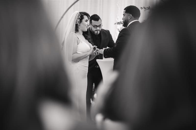 bride putting the wedding ring on her husband during wedding ceremony, photo taken by Nativ Lens