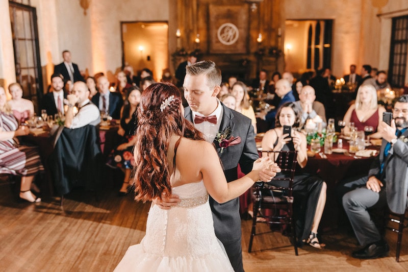 bride and groom enjoying their first dance while their guests watch