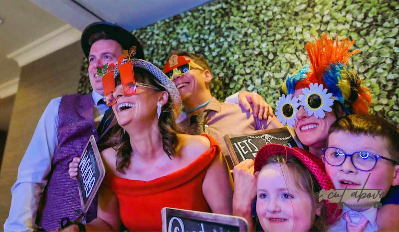 guests wearing fun masks and party hats in photobooth