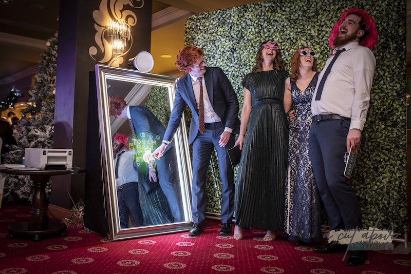 guests laughing while using magic mirror photobooth