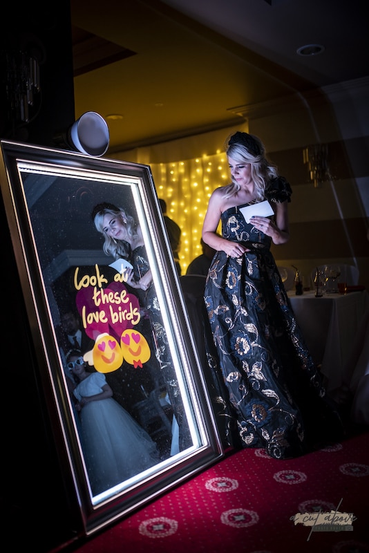 woman looking at magic mirror photo booth from RJM Entertainment