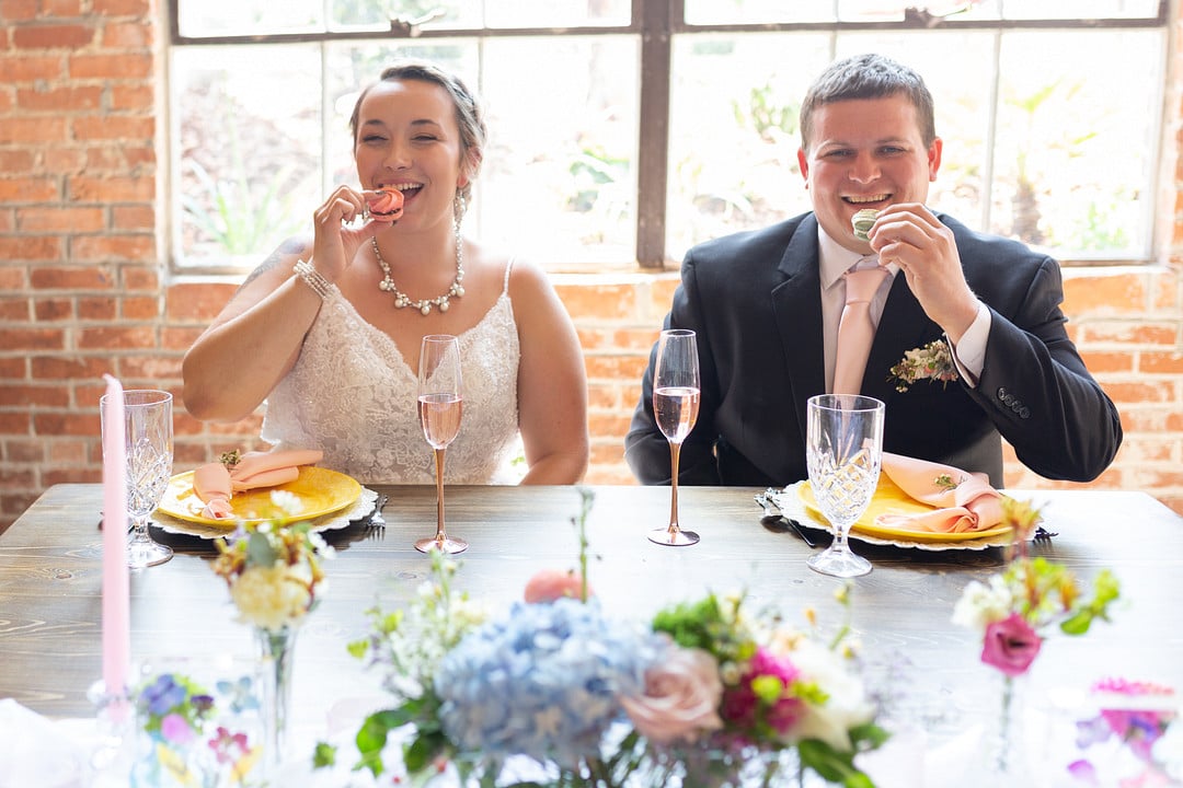 couple eating a macaroon on their plate at their sweetheart table