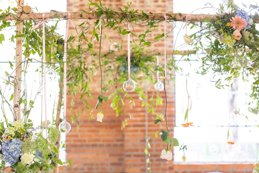 the chuppah set up with greenery and orbs hanging