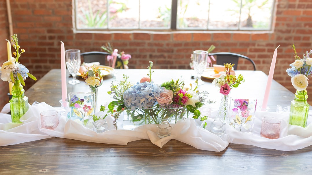 sweetheart table decorated with summer colored flowers for the summer bright wedding inspiration shoot