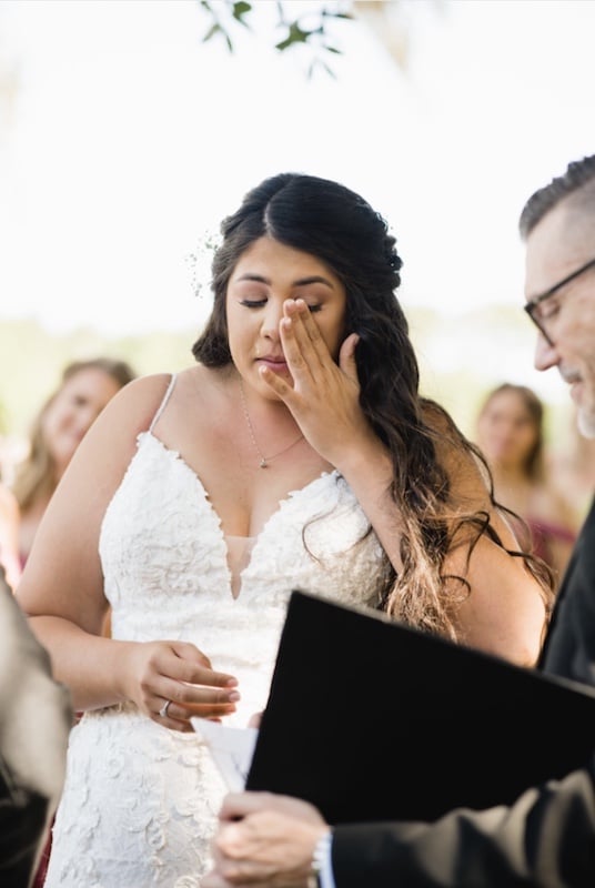 bride wiping away tears during wedding ceremony from Weddings By Sam