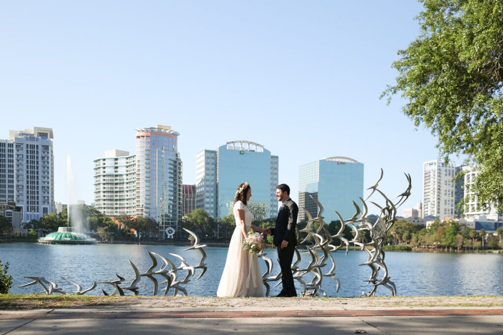 bride and groom standing with Orlando skyline behind them