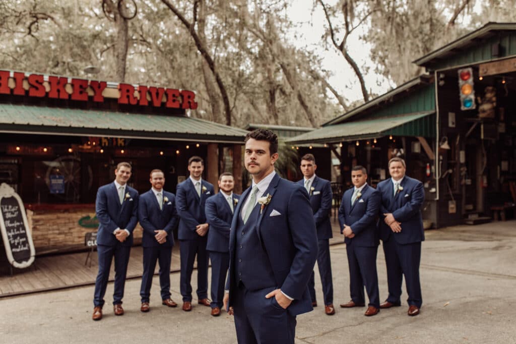 groom standing with his groomsmen lined up behind him