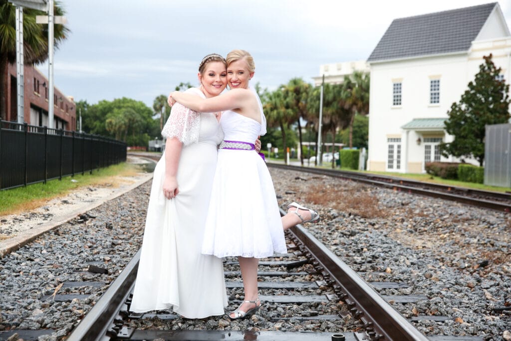two women standing on train tracks hugging