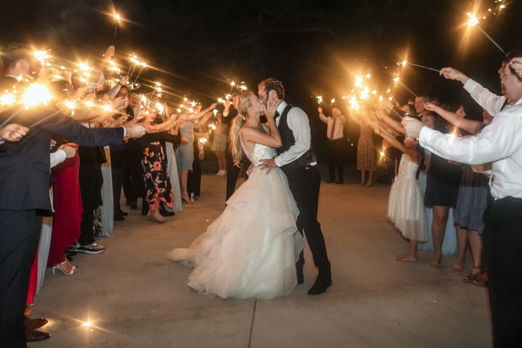 bride and groom kissing during sparkler exit