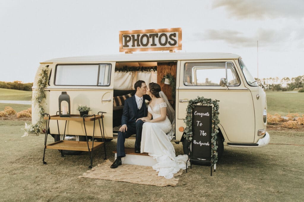 bride and groom sitting in open side of VW bus