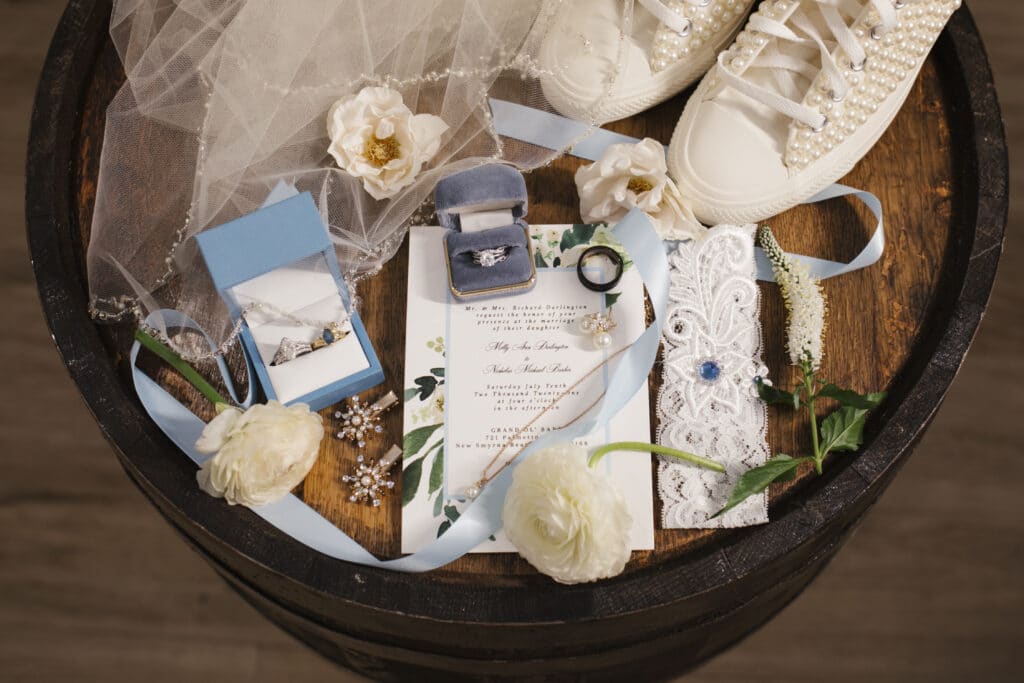 wedding invitations, rings, and other accessories on a wooden barrel