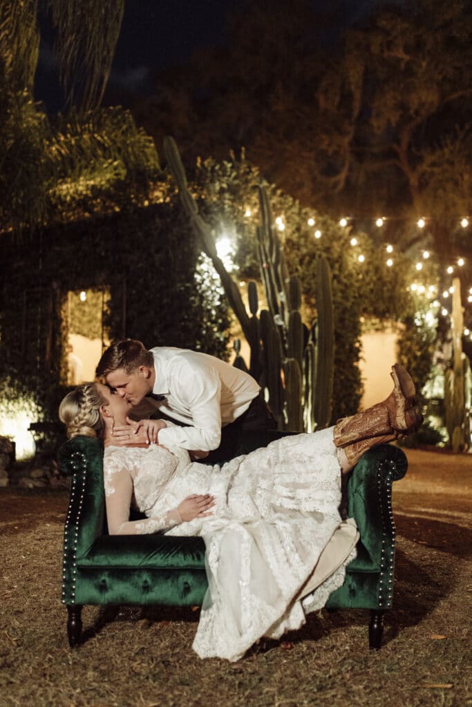 bride lying in couch and getting kissed by groom