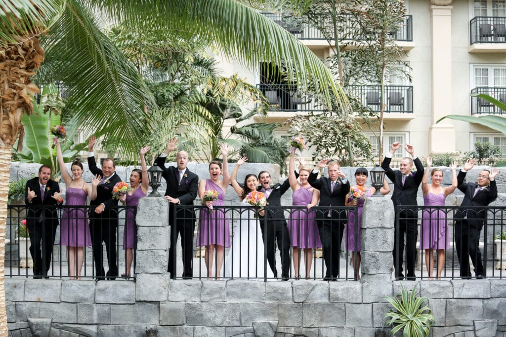 bridal party and bride and groom waving at the camera