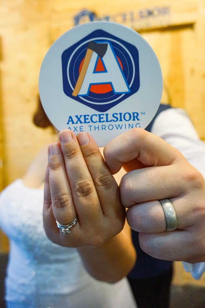 bride and groom holding Axecelsior Axe Throwing drink coaster