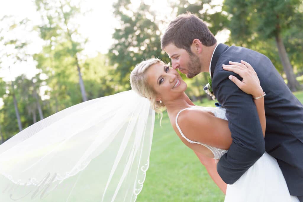 groom leaning in to kiss bride on cheek at Cypress Creek Farmhouse