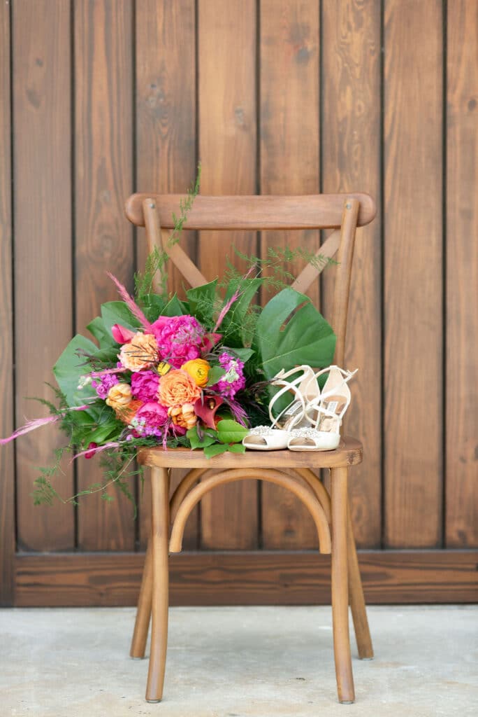 wooden chair with brides shoes and flowers at Cypress Creek Farmhouse