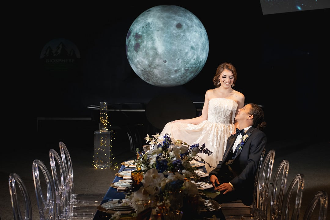 bride and groom at their reception table with the moon in the back for the chic geode wedding inspiration shoot.