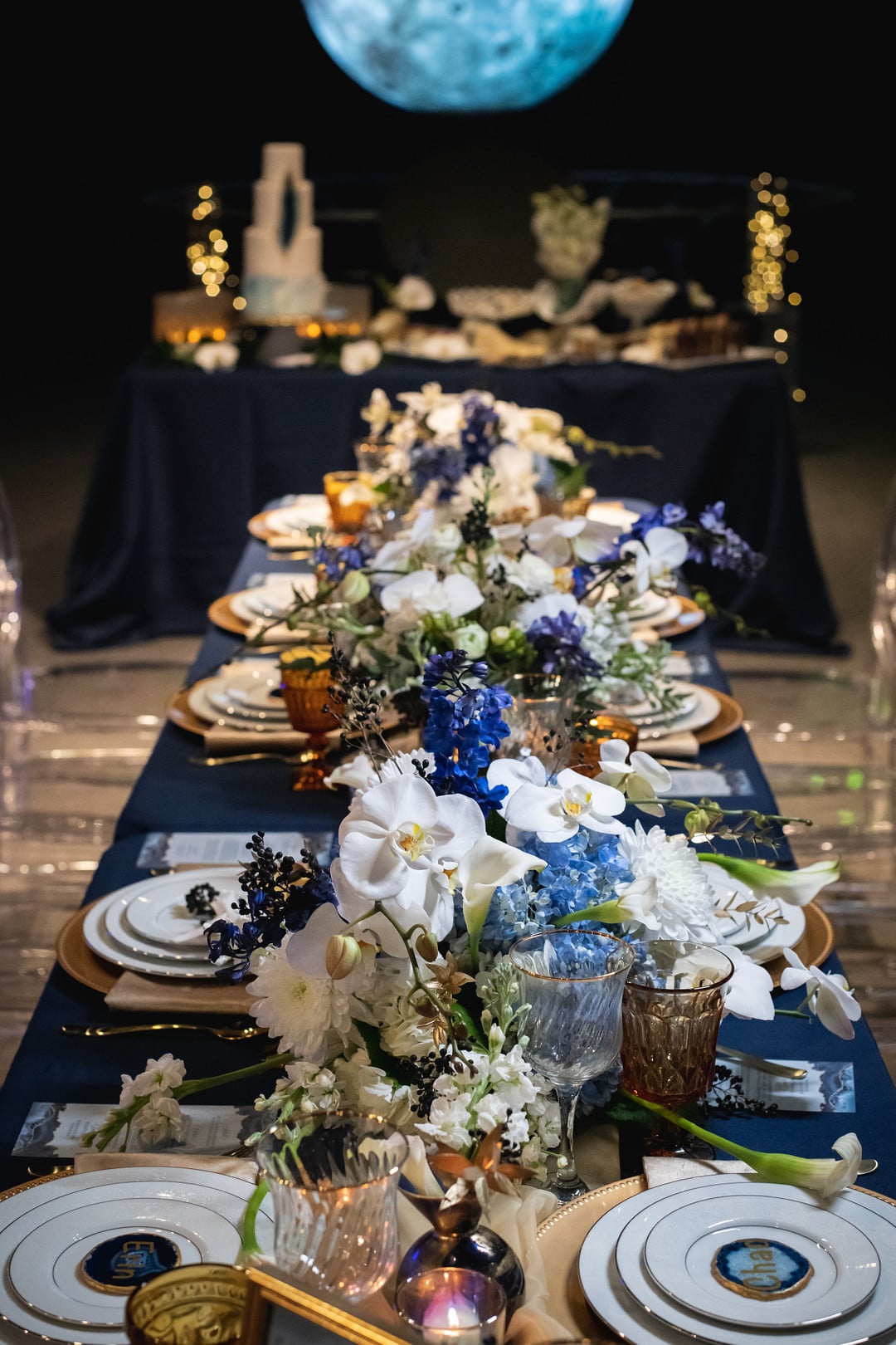 the table set up with lots of blue and white flowers surrounding the fine china