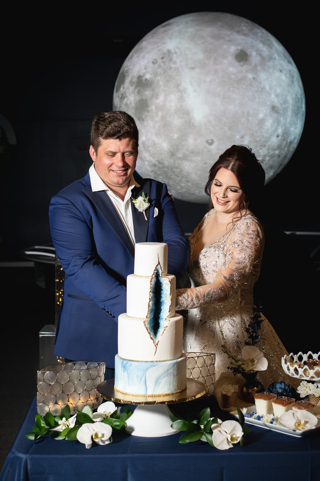 newly wed couple cutting the blue geode cake for the chic geode wedding inspiration shoot