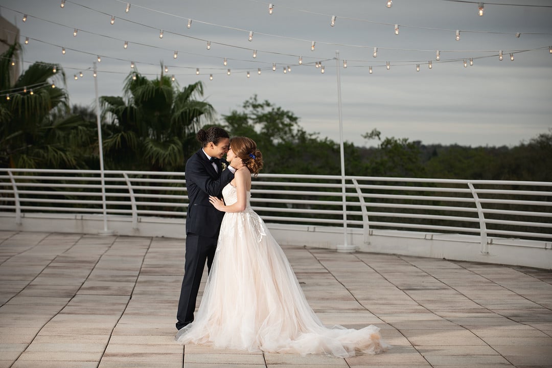 newly wed couple kissing on the terrace for the chic geode wedding inspiration shoot.