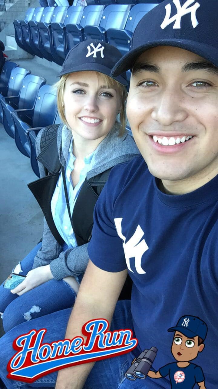 newly engaged couple at a baseball game smiling together