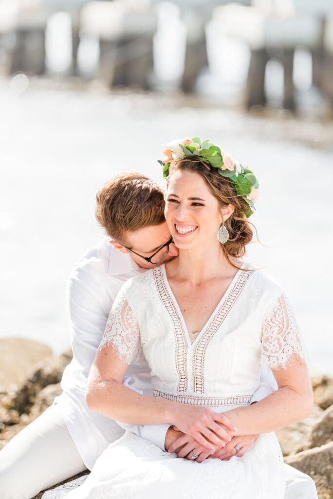 groom hugging the bride from behind while the bride smiles
