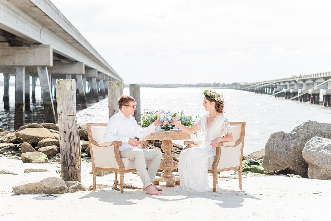 the bride and groom sitting in two gold and white antique chairs